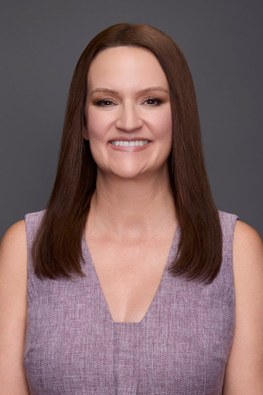 Woman wearing a purple dress with a belt against a grey background